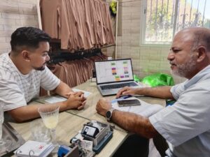Deux hommes discutent autour d'une table avec un ordinateur portable affichant un Business Model Canvas